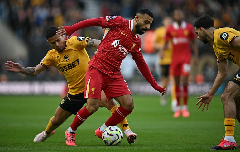 Wolverhampton Wanderers' Brazilian midfielder #08 Joao Gomes (L) vies with Liverpool's Egyptian striker #11 Mohamed Salah during the English Premier League football match between Wolverhampton Wanderers and Liverpool at the Molineux stadium in Wolverhampton, central England on September 28, 2024. (Photo by Paul ELLIS / AFP) / RESTRICTED TO EDITORIAL USE. No use with unauthorized audio, video, data, fixture lists, club/league logos or 'live' services. Online in-match use limited to 120 images. An additional 40 images may be used in extra time. No video emulation. Social media in-match use limited to 120 images. An additional 40 images may be used in extra time. No use in betting publications, games or single club/league/player publications. / 