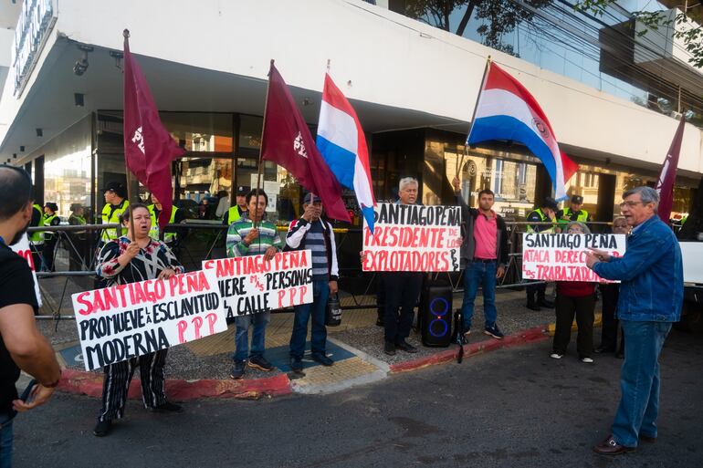 "Santiago Peña promueve la esclavitud moderna", indica uno de los carteles de una participante del mitin del PPP.