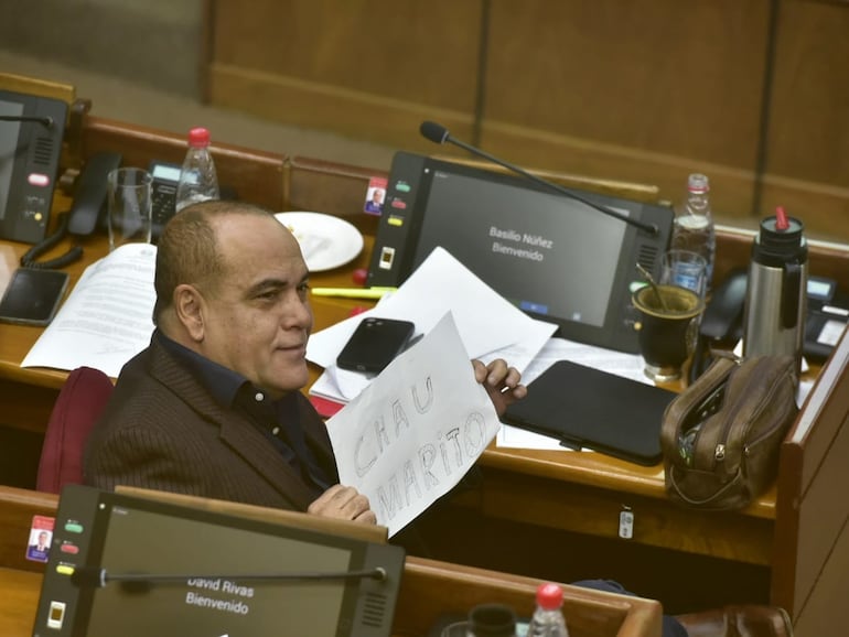 Basilio "Bachi" Núñez muestra un cartel escrito a mano con la leyenda "Chau Marito".