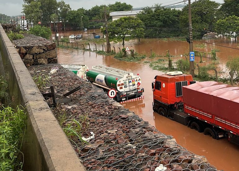 Camiones en una zona de Limpio inundada por fuertes lluvias, el miércoles.