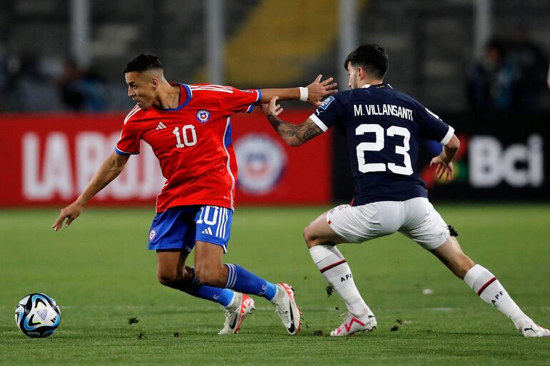 El delantero chileno Alexis Sánchez (i) y el mediocampista paraguayo Mathias Villasanti luchan por el balón durante el partido de fútbol clasificatorio sudamericano para la Copa Mundial de la FIFA 2026 entre Chile y Paraguay en el estadio Monumental David Arellano de Macul, Santiago, el 16 de noviembre de 2023.