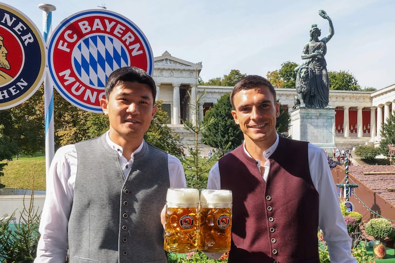 El defensor surcoreano del Bayern de Múnich #03 Kim Min-Jae y el centrocampista portugués del Bayern de Múnich #16 Joao Palhinha (derecha) posan durante la visita anual del club de fútbol al festival de la cerveza Oktoberfest en Múnich, sur de Alemania. 