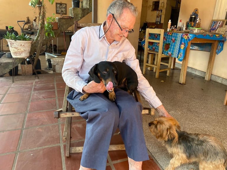 Don Naitzké junto a sus dos perros en el patio de tu casa .