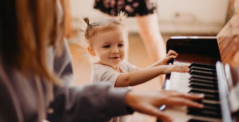 Niña pequeña jugando con el piano