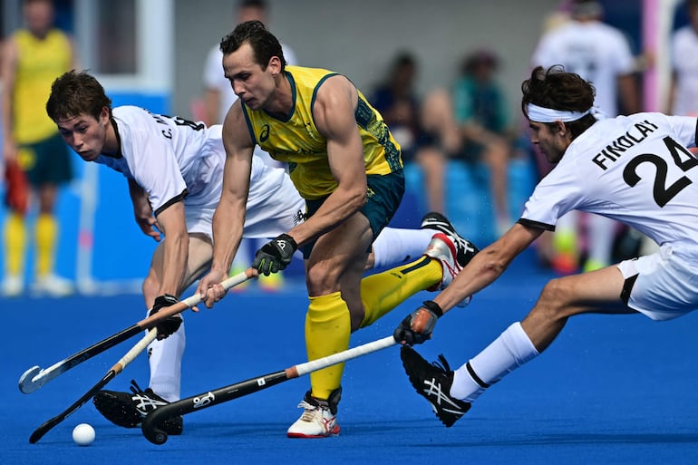 Imagen de archivo. El delantero australiano #02 Thomas Craig (C) está marcado por el mediocampista neozelandés #24 Sean Findlay y el defensor neozelandés #08 Charlie Morrison en el partido de hockey sobre césped del grupo B masculino entre Nueva Zelanda y Australia durante los Juegos Olímpicos de París 2024 en el Yves- Estadio du-Manoir en Colombes el 1 de agosto de 2024.