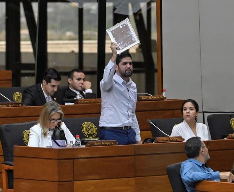 El diputado Raúl Benítez (Partido Encuentro Nacional) blande en alto un espejo durante la sesión en la que se discute la derogación del convenio con la Unión Europea. "Les recomiendo que se compren un espejo para ver si ahí no ven a los culpables del fracaso del sistema educativo", espetó a sus colegas.