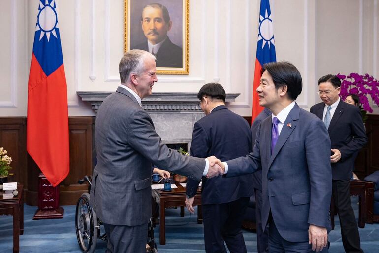 El nuevo presidente de Taiwán, William Lai (d) saluda al senador estadounidense en la oficina presidencial en Taipéi.