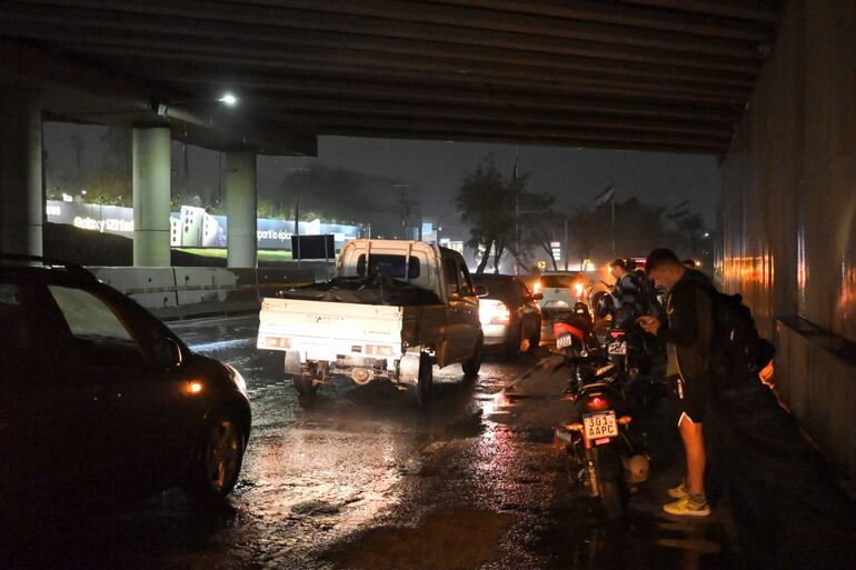 Ciudadanos transitando por la Autopista Silvio Pettirossi durante la tormenta de hoy, jueves.