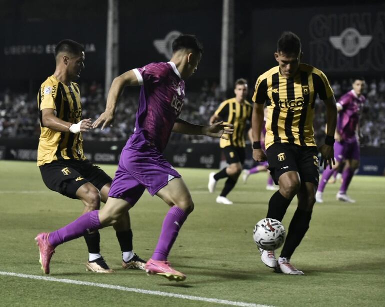 Jugadores de Guaraní y Libertad pelean por el balón en el partido de la fecha 13 del torneo Clausura 2023 del fútbol paraguayo en el estadio La Huerta, en Asunción.