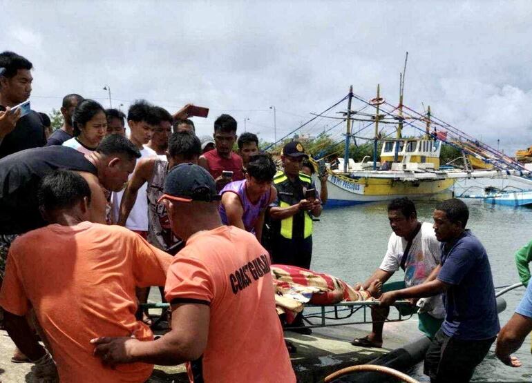 El cuerpo de un pescador fallecido en Infanta, en la provincia filipina de Pangasinan, es retirado por vecinos y guardias costeros, el martes.