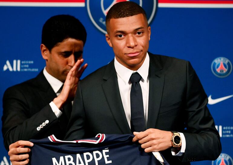 (FILES) Paris Saint-Germain's CEO Nasser Al-Khelaifi (L) and French forward Kylian Mbappe (R) pose with a jersey at the end of a press conference at the Parc des Princes stadium in Paris on May 23, 2022. Paris Saint-Germain announced that it would not pay the 55 million in unpaid dues to Kylian Mbappe, which the French Ligue de Football Professionnel (LFP) ordered it to pay the player, warning that the player would have to take legal action. (Photo by FRANCK FIFE / AFP)