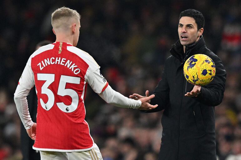 El entrenador español del Arsenal, Mikel Arteta (derecha), pasa un balón al defensa ucraniano #35 del Arsenal, Oleksandr Zinchenko, para que realice un saque de banda durante el partido de fútbol de la Premier League inglesa entre el Arsenal y el Wolverhampton Wanderers en el Emirates Stadium de Londres el 2 de diciembre de 2023.