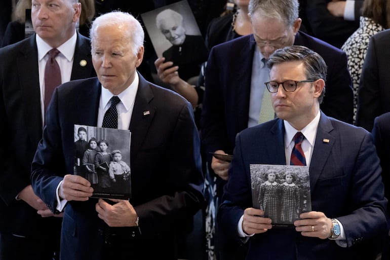 El presidente estadounidense Joe Biden (izquierda) y el presidente de la Cámara de Representantes, Mike Johnson (derecha), sostienen fotografías de personas que murieron durante el Holocausto en la ceremonia de los Días de Recuerdo del Museo Conmemorativo del Holocausto de Estados Unidos. En el Capitolio de los Estados Unidos en Washington, DC.