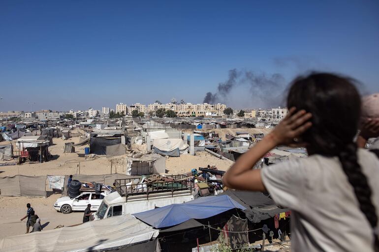 Palestinos desplazados huyen en medio de zonas de bombardeo israelí declaradas inseguras por la ocupación israelí tras ser clasificadas como zonas humanitarias en Khan Yunis, sur de la Franja de Gaza.