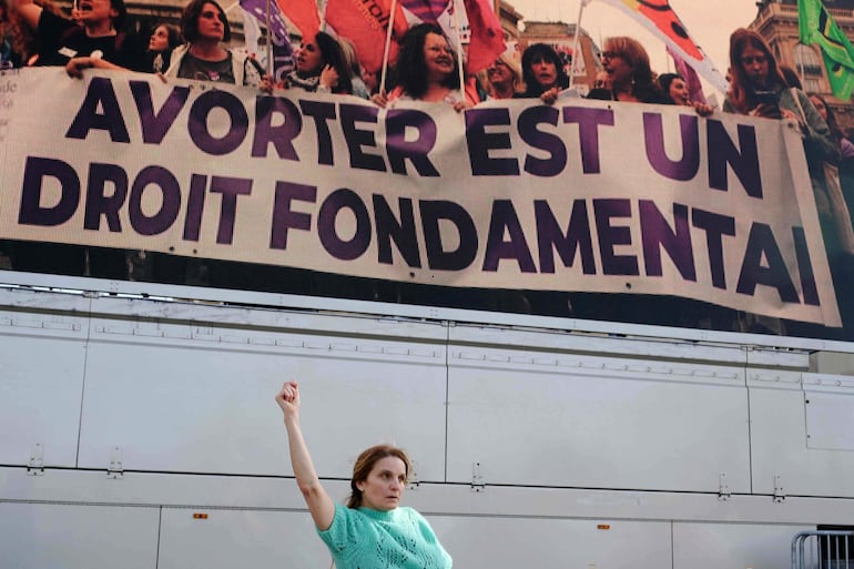 "Abortar es un derecho fundamental" reza este mensaje ante el cual una mujer eleva un puño y danza, en Trocadero, París. 