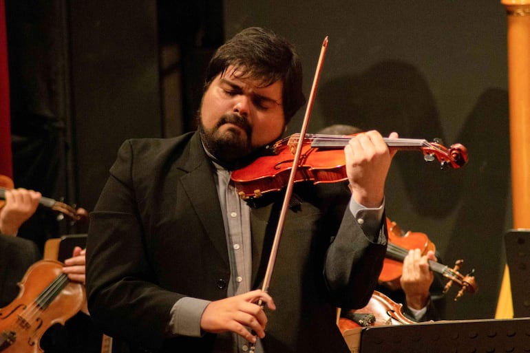 El violinista invitado de este concierto es el paraguayo Óscar Aguilar Mas.