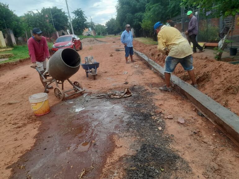 Un grupo de vecinos del asentamiento San Cayetano trabaja en la colocación del cordón de cemento  de una de las calles de la comunidad