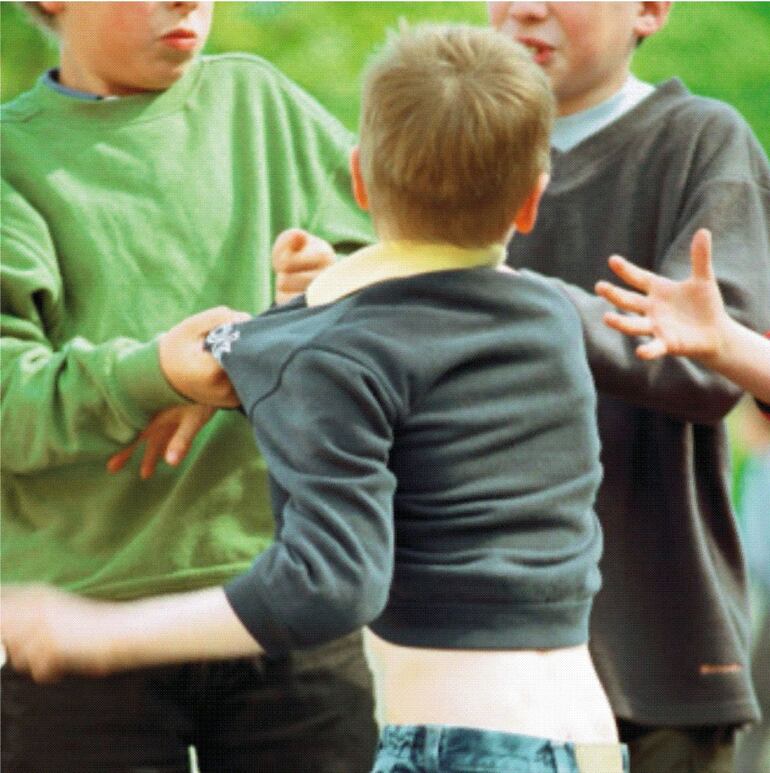 Imagen referencial de un niño siendo agredido por otros.