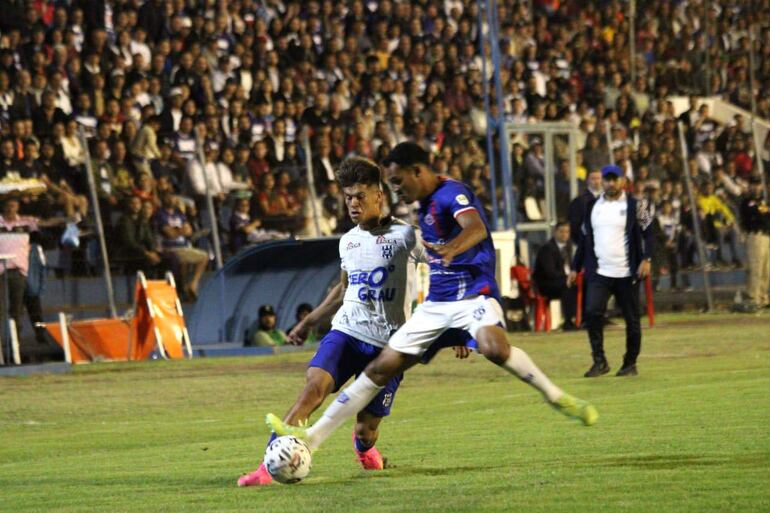 Disputa entre volente del "Gallo", Javier Domínguez y el lateral Carlos Montiel, de fondo el entrenador Felipe Giménez. (Foto: APF)