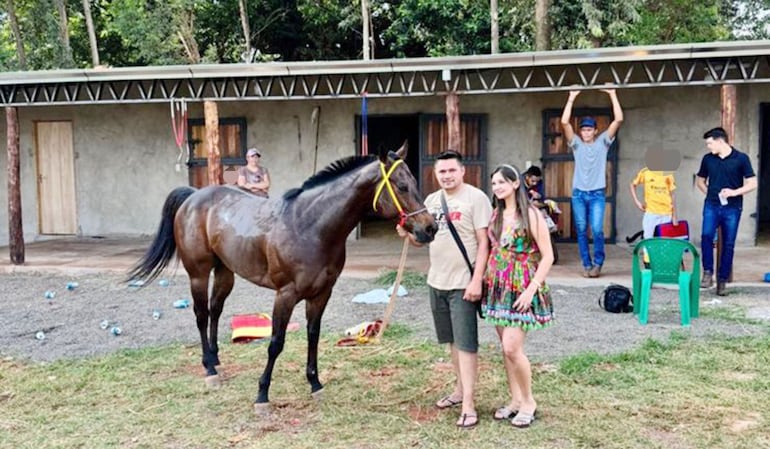 Erwin Rolando Carneiro Gómez y su mujer posan junto al caballero con el que ganaron una carrera. Fue momentos antes del homicidio.