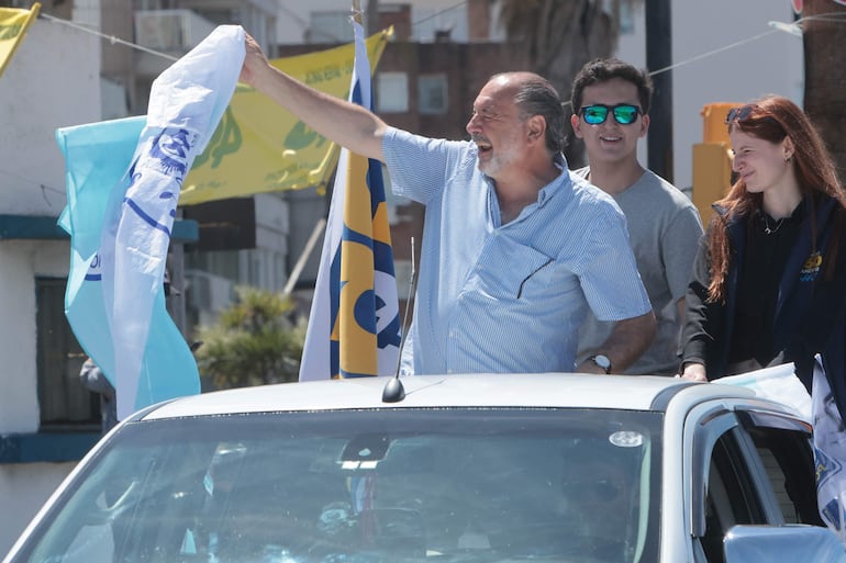 Simpatizantes del candidato a la presidencia de Uruguay por el oficialista Partido Nacional, Álvaro Delgado, participan de una caravana, en Montevideo (Uruguay). Las calles de Montevideo se tiñeron este domingo del rojo, azul y blanco y del celeste y blanco de las banderas flameadas por los miles que acompañaron las caravanas del oficialista Partido Nacional y del opositor Frente Amplio, cuyos candidatos son los favoritos de cara a las elecciones de Uruguay. 
