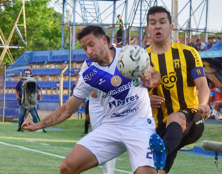 El defensor de Ameliano, Julio González, cubre el balón ante la presión de Néstor Camacho.