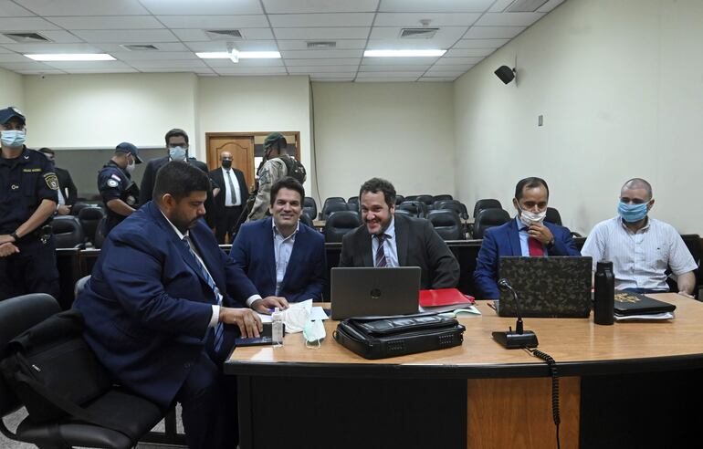 Cristian Turrini (segundo de la izquierda) y Alberto Ayala Jacquet (derecha) juntos a sus defensores en la audiencia preliminar por la megacarga de droga en el puerto de Villeta.