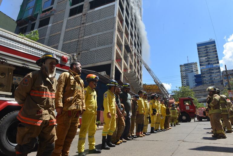 Formación de bomberos, al pie del edificio Flytec de Ciudad del Este que se ardió en llamas durante cinco días.