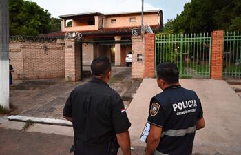 Agentes policiales intercambian información frente a la casa del periodista Aníbal Velázquez, que fue objeto de hurto domiciliario.