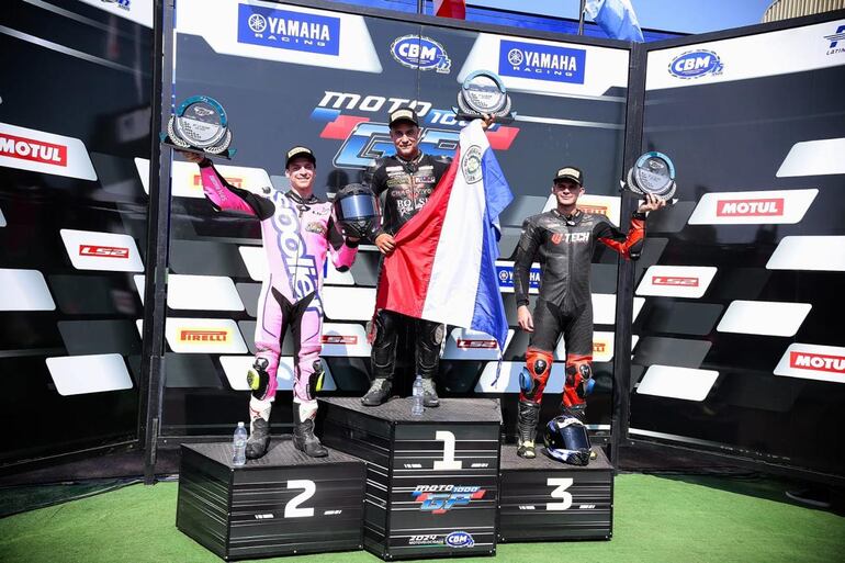 El paraguayo Pedro Valiente posa con su trofeo y la bandera tricolor en alto.